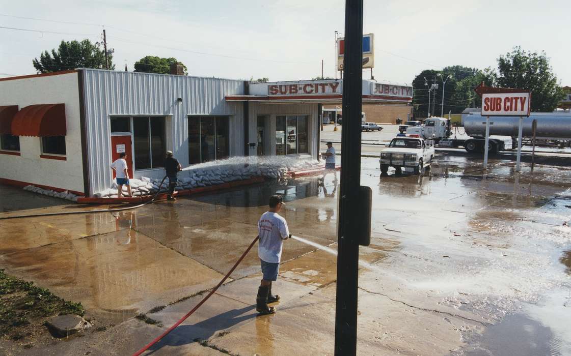Floods, sub city, concrete, Iowa History, history of Iowa, sandwich, Motorized Vehicles, Businesses and Factories, Civic Engagement, cleaning, truck, boots, Waverly, IA, water, Iowa, sandbag, Waverly Public Library, hose