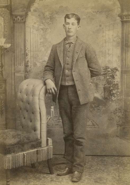 sack coat, Postville, IA, Iowa, stripe, vest, Iowa History, chair, patterned carpet, Olsson, Ann and Jons, Portraits - Individual, painted backdrop, man, history of Iowa, cabinet photo, suit