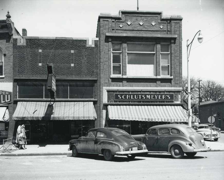 license plate, sign, history of Iowa, window, Businesses and Factories, Waverly, IA, Waverly Public Library, Main Streets & Town Squares, Iowa, car, Motorized Vehicles, lamppost, brick building, building, stop sign, Iowa History, Cities and Towns, people