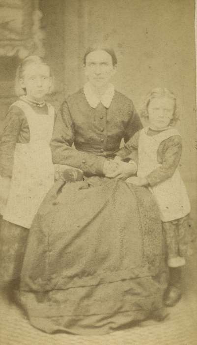 Portraits - Group, carte de visite, Iowa, mother, Iowa History, bishop sleeves, patterned carpet, Children, girls, hoop skirt, Olsson, Ann and Jons, dress, history of Iowa, Cedar Falls, IA, painted backdrop, apron, dropped shoulder seams, pantaloons