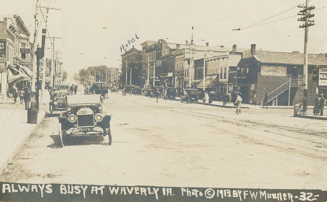 hat, horse and buggy, lightpost, Cities and Towns, hotel, animal, history of Iowa, Motorized Vehicles, Main Streets & Town Squares, Iowa History, electrical wires, bank, dentist, awning, Iowa, stairs, Meyer, Sarah, car, sidewalk, street light, Businesses and Factories, Waverly, IA, dirt road, license plate