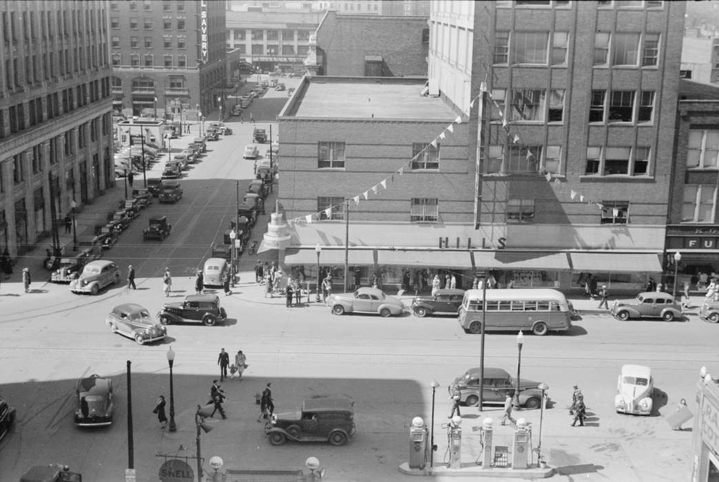 Library of Congress, history of Iowa, Businesses and Factories, downtown des moines, Main Streets & Town Squares, Iowa, Motorized Vehicles, Aerial Shots, pedestrian, street lamps, gas pump, Iowa History, intersection, Cities and Towns, ford model a, downtown, Portraits - Group, banner, bus, cars