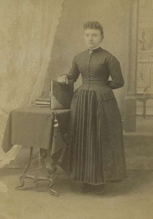 photo album, frizzy bangs, table, history of Iowa, Iowa History, woman, Olsson, Ann and Jons, books, cabinet photo, Iowa, painted backdrop, Des Moines, IA, Portraits - Individual
