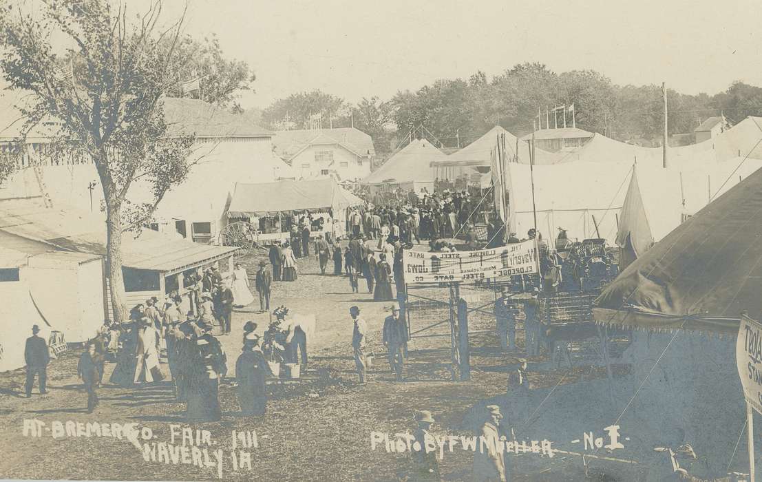 Outdoor Recreation, banner, homburg hat, bowler hat, Fairs and Festivals, long skirt, Children, Entertainment, Aerial Shots, Cities and Towns, history of Iowa, Motorized Vehicles, Iowa History, Iowa, Families, Meyer, Sarah, cars, tents, Waverly, IA, county fair, large decorated hat