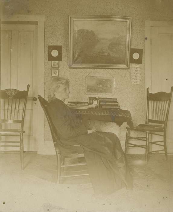 table cloth, tablecloth, old woman, Iowa History, wallpaper, rocking chair, Waverly, IA, Waverly Public Library, book, history of Iowa, rug, Iowa, Portraits - Individual, Homes, painting, chair