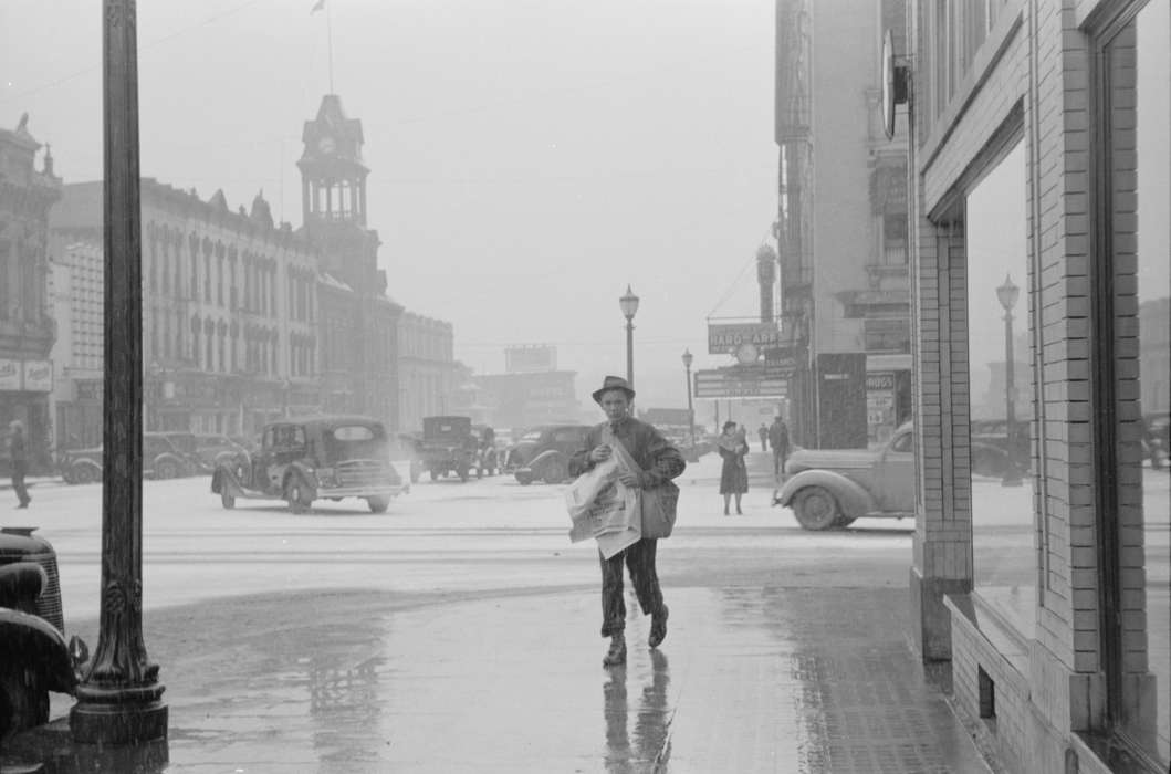 mainstreet, traffic, paper route, history of Iowa, Library of Congress, Motorized Vehicles, storefront, Main Streets & Town Squares, newsboy, Iowa, Cities and Towns, Businesses and Factories, Labor and Occupations, Children, street corner, Iowa History, Winter