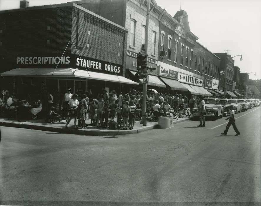 Cities and Towns, awning, Motorized Vehicles, Iowa History, Waverly Public Library, jewelry store, Iowa, Businesses and Factories, history of Iowa, drugstore, clothing store, automobile, street parking, Waverly, IA, crowd, paint store, Main Streets & Town Squares