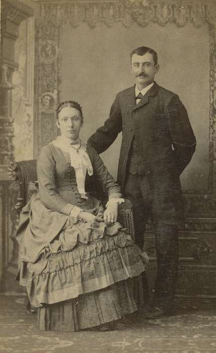 woman, Manchester, IA, ruffles, brooch, man, carte de visite, Iowa, vest, correct date needed, necklace, couple, Families, lace collar, Portraits - Group, bustle, Iowa History, painted backdrop, mustache, history of Iowa, hairnet, frock coat, Olsson, Ann and Jons, jabot, bow tie