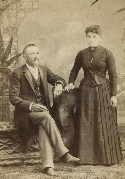 Portraits - Group, woman, cabinet photo, Waterloo, IA, Iowa History, painted backdrop, mustache, brooch, history of Iowa, frizzy bangs, man, suit, frock coat, dress, vest, Olsson, Ann and Jons, pocket watch chain, Iowa