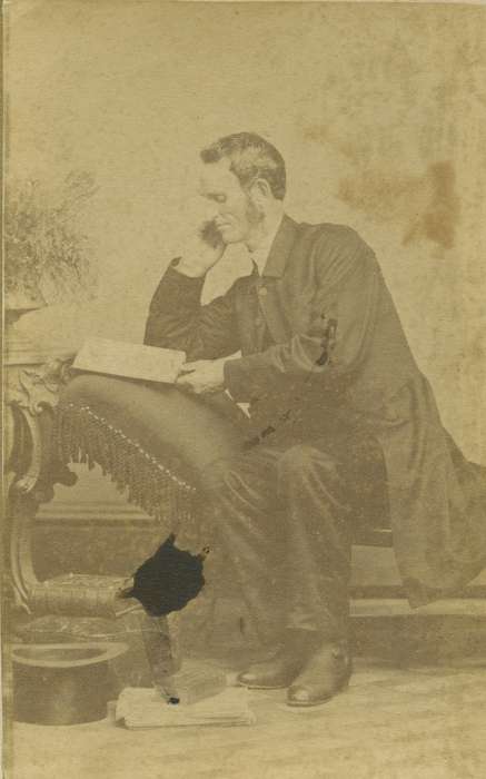 carte de visite, Iowa, sideburns, top hat, chair, frock coat, reading, Olsson, Ann and Jons, Portraits - Individual, book, Maquoketa, IA, painted backdrop, photo album, pillow, history of Iowa, Iowa History, man