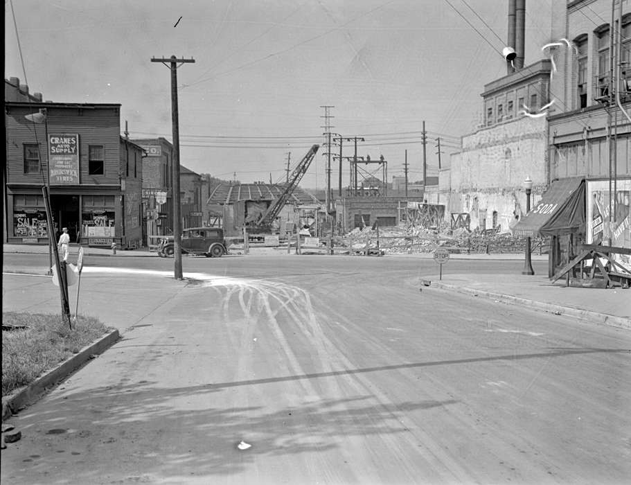 construction, Ottumwa, IA, history of Iowa, Lemberger, LeAnn, Motorized Vehicles, storefront, telephone pole, crane, Iowa, Cities and Towns, car, stop sign, Iowa History, veranda