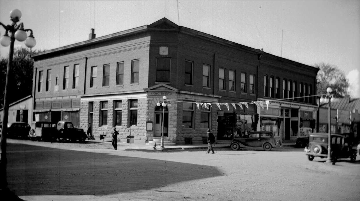 flag, Main Streets & Town Squares, history of Iowa, Iowa History, IA, Lemberger, LeAnn, Motorized Vehicles, Businesses and Factories, car, dirt road, street corner, street light, Iowa, Cities and Towns, bank