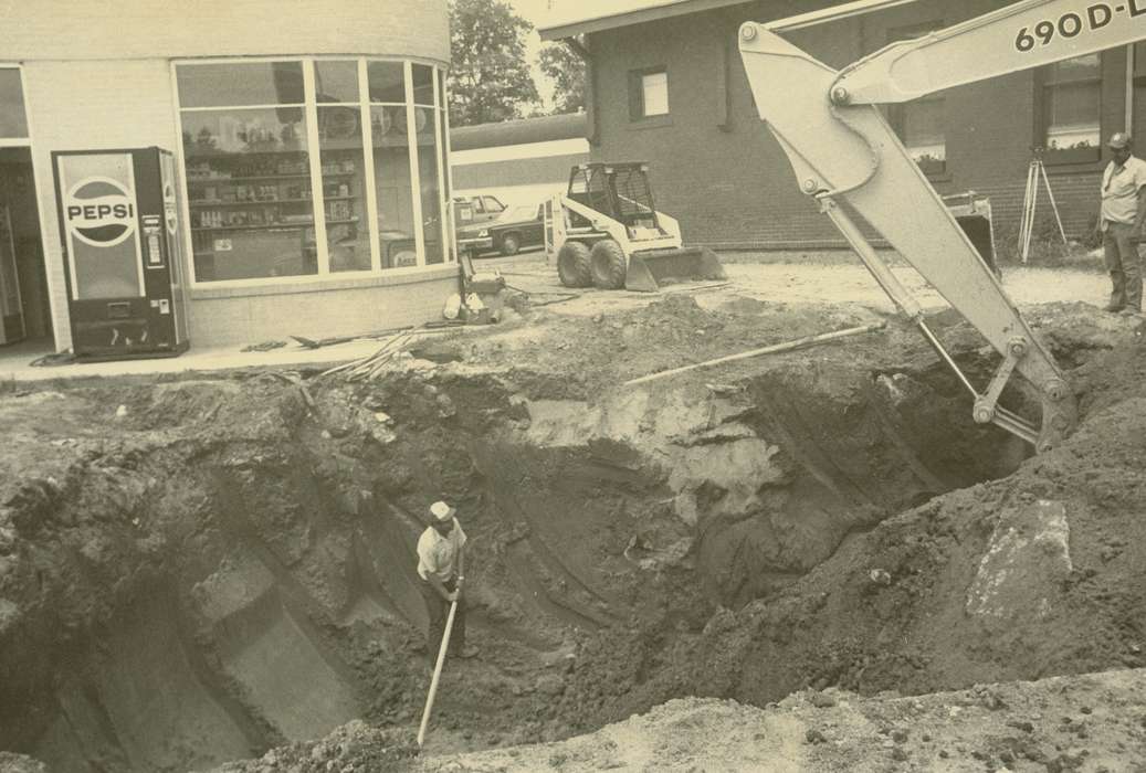 hole, bobcat loader, history of Iowa, pop machine, Iowa History, Motorized Vehicles, Businesses and Factories, excavator, brick building, car, Waverly, IA, gas station, Iowa, Waverly Public Library, Labor and Occupations